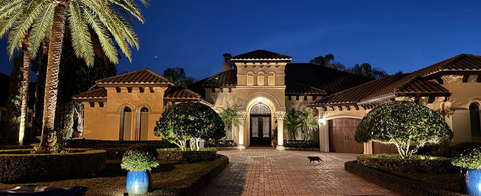 Florida home at dusk with landscape and pathway lighting installed
